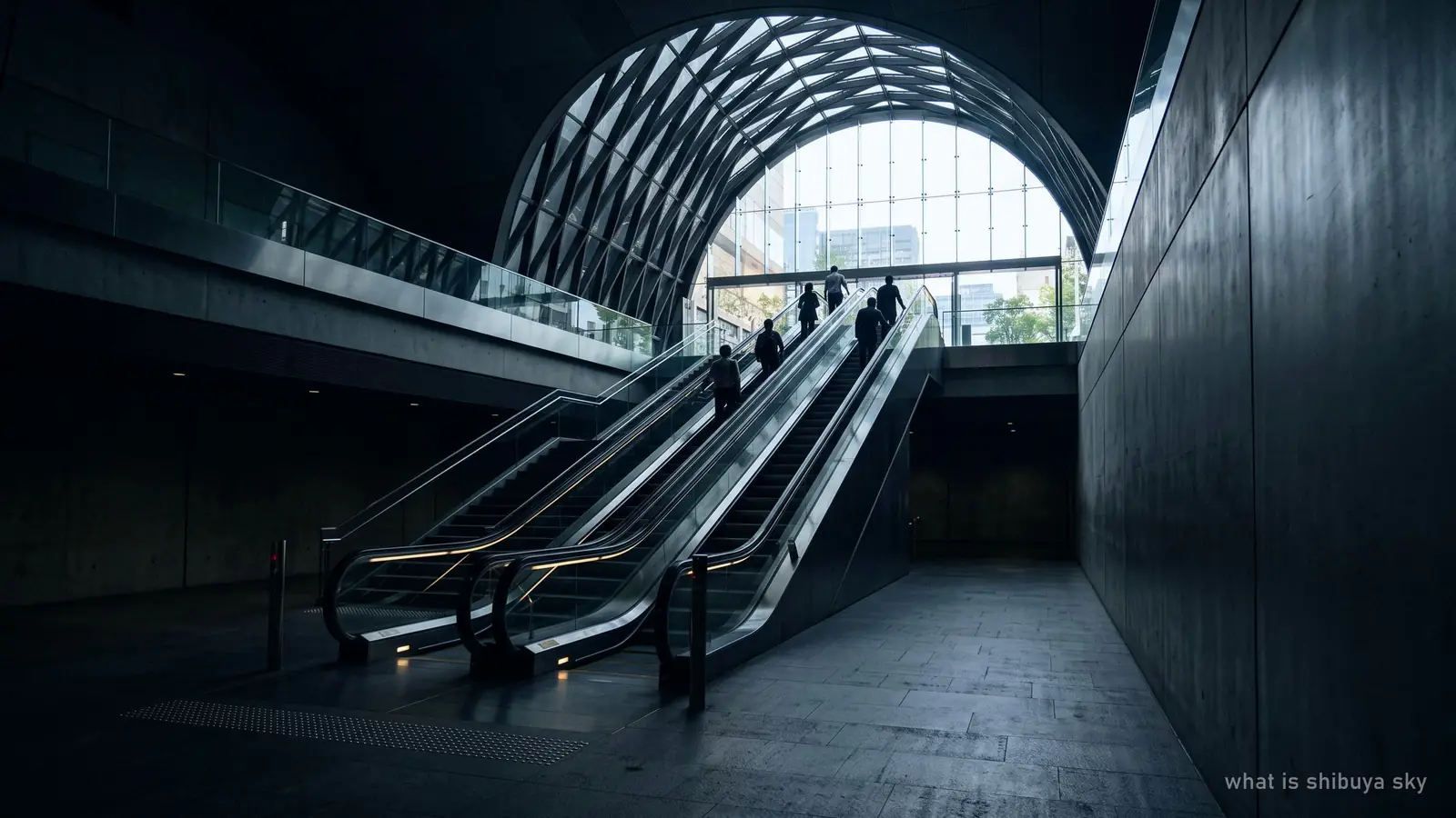 A long escalator rising through a dark, dramatically lit transition space toward daylight
